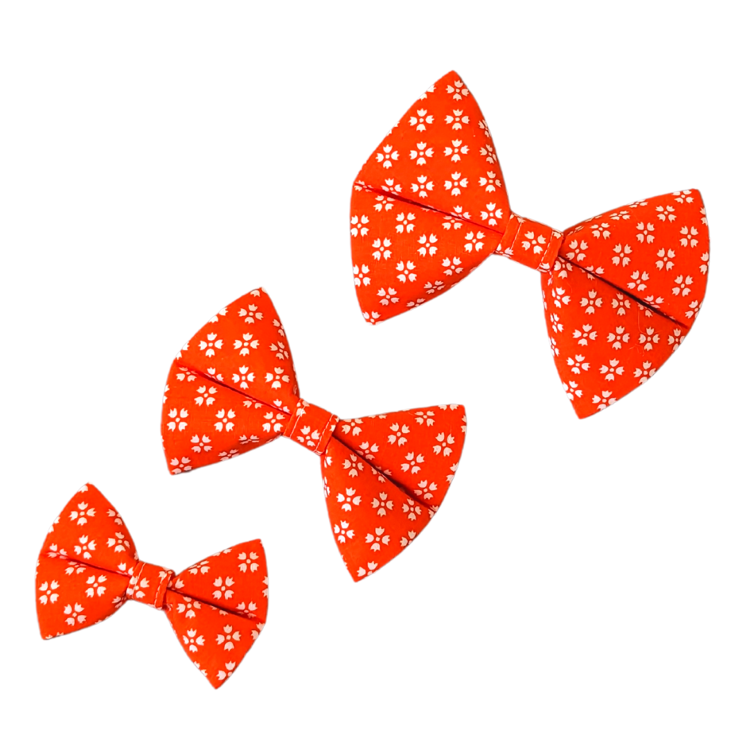 Image showcasing our Bright Orange with White Floral Bow Ties in three sizes: Small, Medium, and Large, providing size comparison for reference.