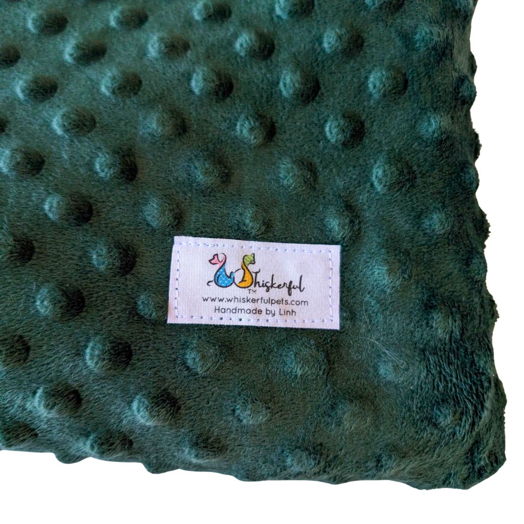 Emerald green bed for cats and small dogs with a label on a white background