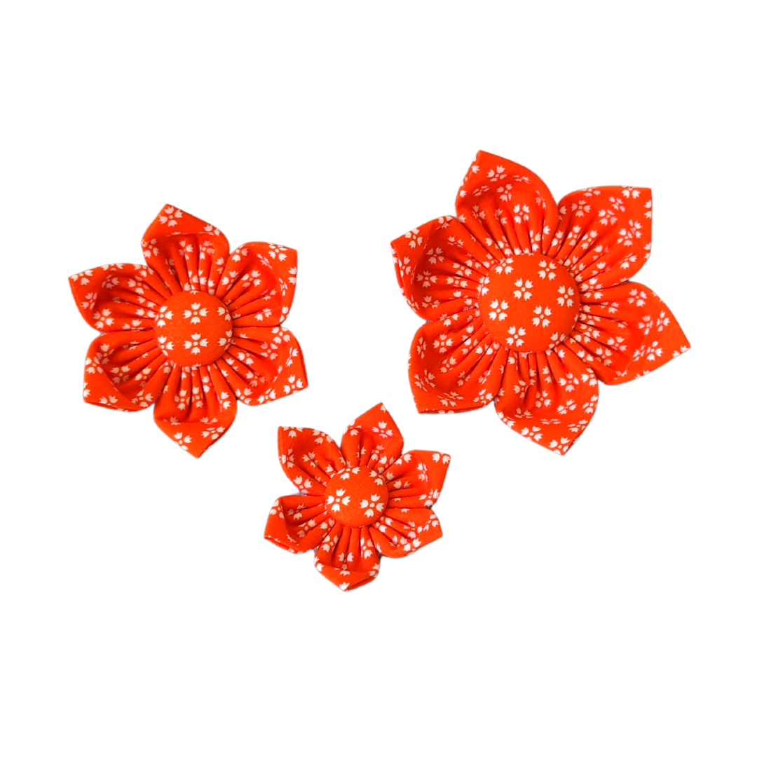Image showcasing the size comparison of three Bright Orange with Whimsical White Floral Kanzashi Flowers: Small, Medium, and Large.