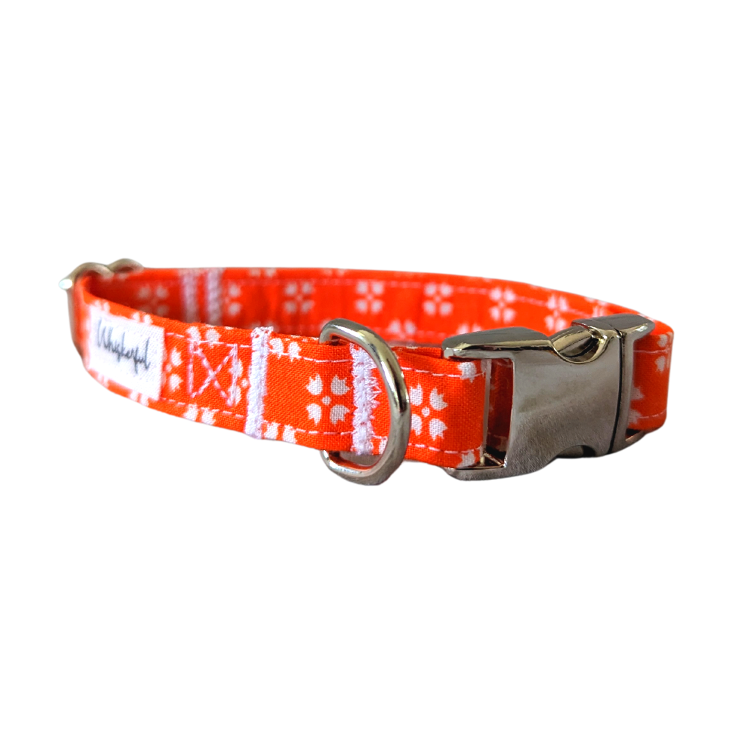 Image of our Medium Bright Orange with White Floral Collar featuring medium interfacing inside to maintain its shape. The collar is equipped with contoured aluminum hardware for enhanced comfort on pets.